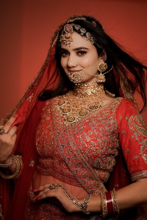 Bridal styling with red veil and intricate gold jewellery